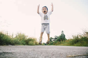 Fototapeta premium Healthy And Cheerful Asian Kids Is Jumping Happily , Outdoor