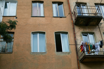 facade of an old brown block of flats with tall windows and balconies