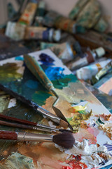 Fototapeta premium Artistic brushes and stacks lie on a palette with paints