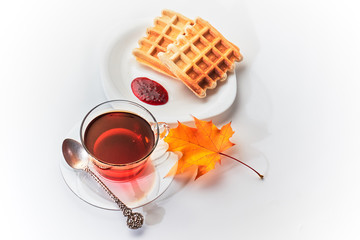 A cup of tea and crispy wafers./A cup of tea and crispy wafers poured with raspberry jam. White...
