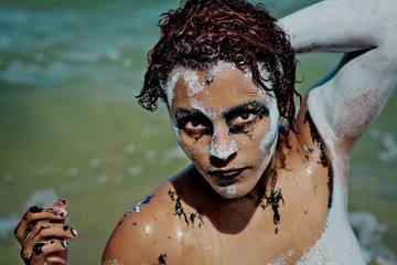 The girl washed in the sea after painting on the body and face