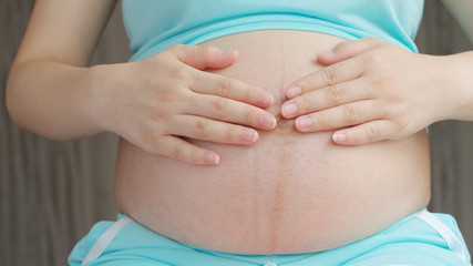 Pregnant women caressing her belly