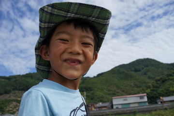 少年の笑顔　夏休み　帽子　喜び　笑顔　屋外