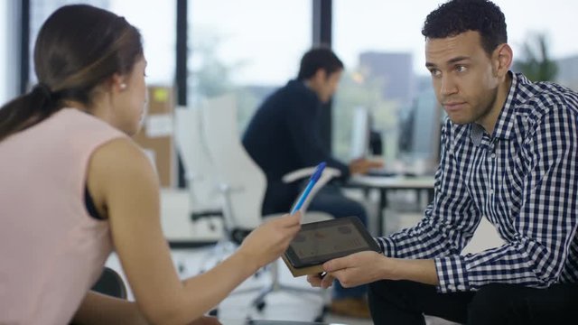  Business manager in discussion with employee looking at performance figures