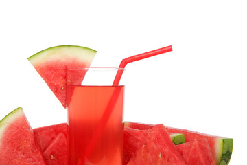 Close up of glass of watermelon lemonade surrounded by fruit. Red straw, slice of watermelon on side of cup, isolated on white background.