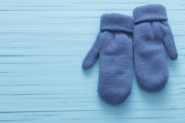 blue mittens on blue wooden background