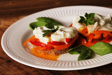 Eggs Benedict. Toasted muffins with paprika, spinach, poached eggs