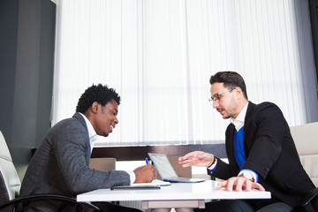 Two young businessmen, white desk, job interview, teamwork. Two successful male entrepreneurs at office work together