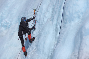 An ice climber makes his way on a frozen waterfall