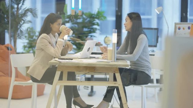  Confident successful businesswomen in a meeting looking over paperwork