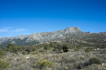 Views of Guadarrama Mountains (Madrid, Spain) with La Bola del Mundo peak, La Barranca Valley and La Maliciosa peak in the background. Photo taken from the River Navacerrada