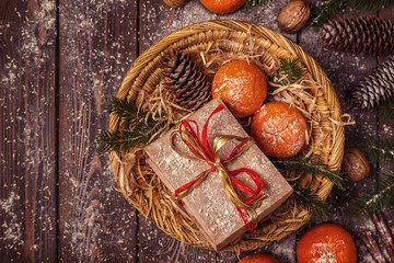 Christmas composition with tangerines, gift boxes, cones on a dark wooden background.