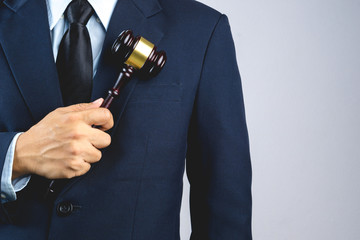 Business man hand holding wooden judge's gavel as a law or justice sign