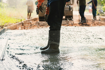 worker leveling concrete pavement for mix cement at construction site