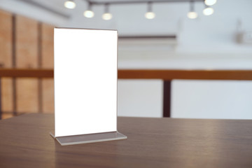 Mock up Menu frame standing on wood table in Bar restaurant cafe. space for text.