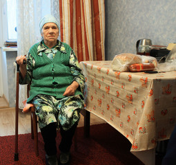 poverty old woman sitting on chair in the kitchen