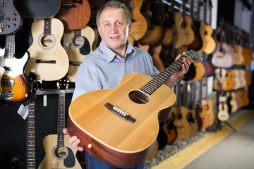 male is standing with modern guitar