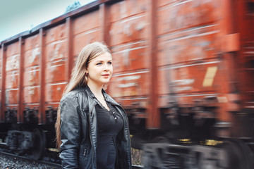 Fototapeta na wymiar Nice girl on a railway road near moving train
