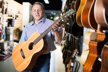 male is standing with modern guitar