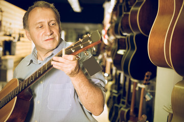 male is standing with modern guitar