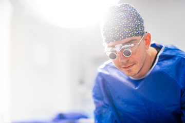 Close up portrait of male surgeon wearing loupes for surgery