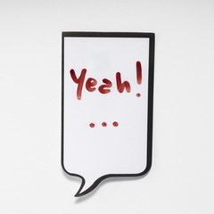 a white memo pad with the shape of a comic with the inscription "yeah!...."