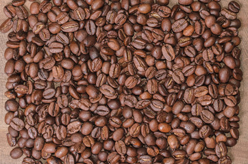 Fototapeta premium Background of coffee beans on a wooden board close up