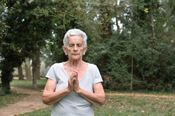 Naklejka na ściany i meble elderly woman practicing yoga outdoors