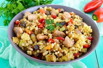 Warm dietary salad from baked vegetables (zucchini, sweet pepper, eggplant, onion), chicken and couscous. Tabbouleh - Eastern snack.
