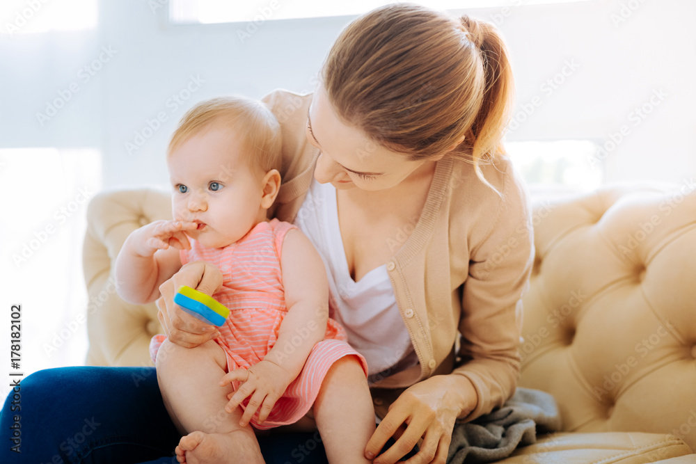 Wall mural loving kind mother showing a new bright toy