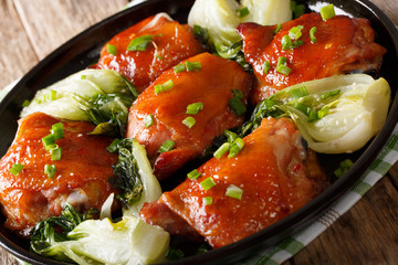 Fried chicken thighs with pak choy, ginger, garlic and green onions closeup. horizontal