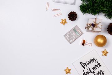 Home office desk workspace with quotes diary, golden paperclip, golden ornaments on white background. flat lay, top view. Winter christmas holiday background.