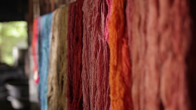 Colorful of raw silk thread on a rail.