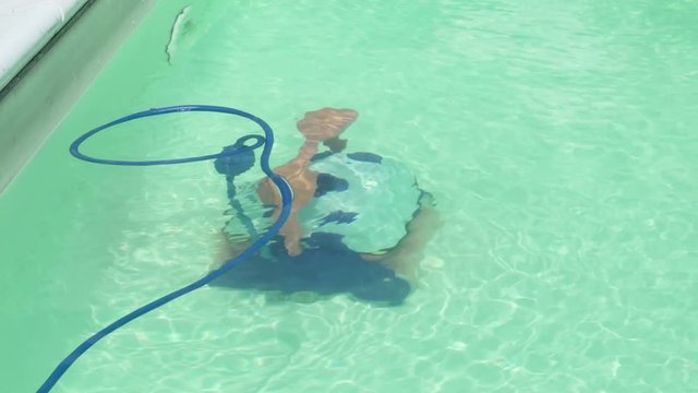 A robotic pool cleaner work across in private pull in the summer season..01