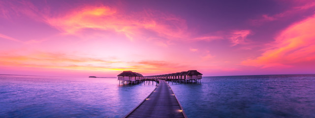 Luxury water bungalow in sunset time. Amazing colors and seascape view