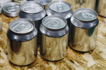 sample of aluminum cans show on the wooden table at the packaging factory.