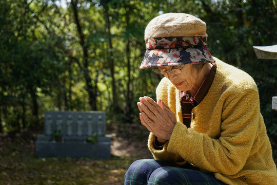 Elderly woman visiting the family grave