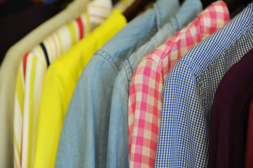 Background texture from a row of colored shirts and blouses on a hanger