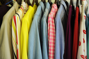 Background texture from a row of colored shirts and blouses on a hanger