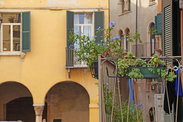 Balcony with flowers. Flowers on the balcony in the old Italian city.