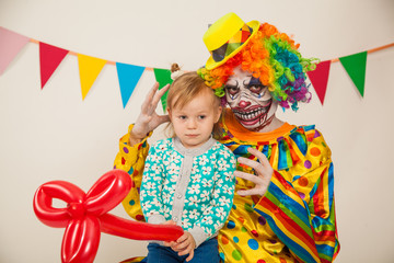 a terrible clown and a child. Halloween. The crazy clown. Childish fear