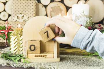 woman sets the date on the wooden calendar - January 7 - orthodox Christmas