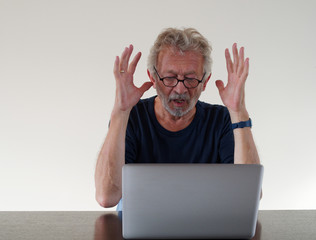 Verärgerter Mann mit Bart am Laptop