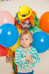 Fototapeta na wymiar a terrible clown and a child. Halloween. The crazy clown. Childish fear