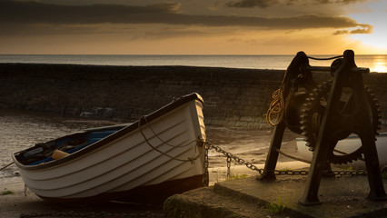 A rowing boat in the harbour at sunset © olavs