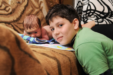 Brother play with a younger newborn brother