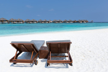 Wooden sunbeds on pristine Maldives beach