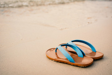 Fototapeta na wymiar Blue sandal on the beach concept time to travel , holiday summer season
