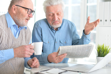 senior men reading newspaper