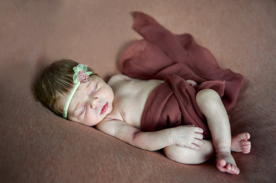 The newborn sleeps on the banquet. Photo in cream tones
